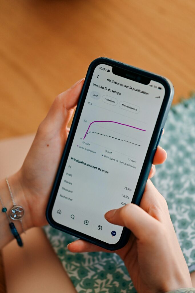 Smartphone mit Social-Media-Statistiken in der Hand