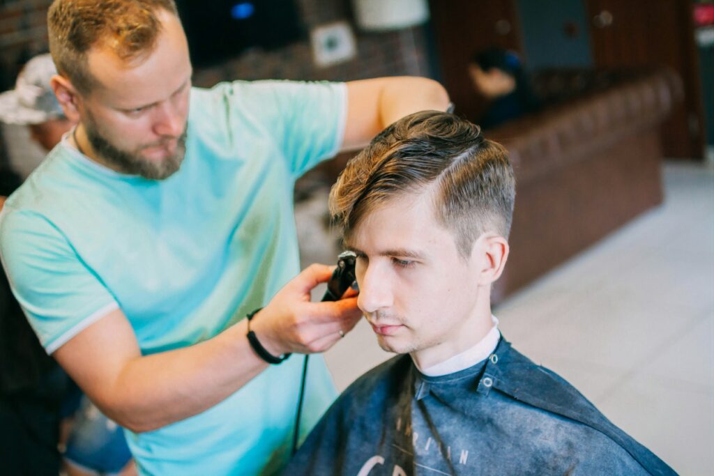 Friseur schneidet einem Kunden die Haare im Salon